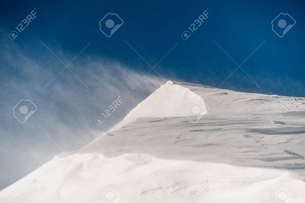 90315297-clear-and-high-mountain-snowdrift-and-strong-blowing-wind-under-the-bright-and-blue-sky.jpg